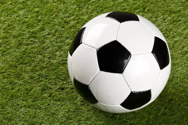 Jeden fotbalový míč na zeleném trávníku pozadí s kopírovacím prostorem — Stock fotografie