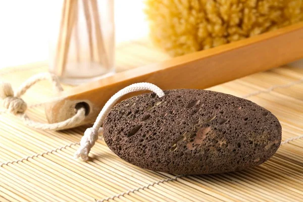 Black lava pumice stone with natural spa or bath utensils — Stock Photo, Image