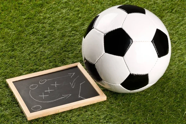 Fútbol pelota deportiva con estrategia de juego dibujo pizarra en la hierba — Foto de Stock