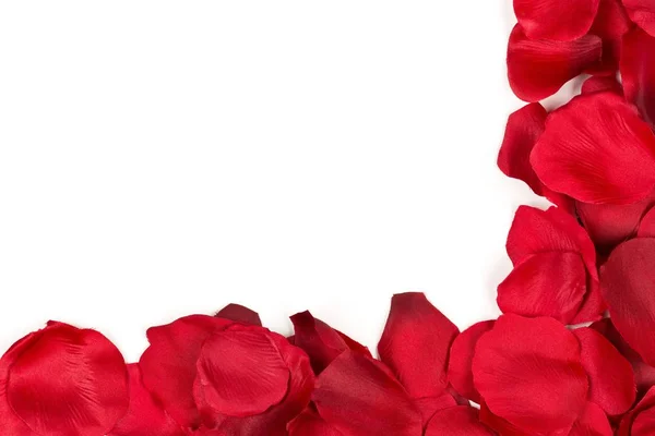 Red fabric rose petals corner over white background top view — Stock Photo, Image