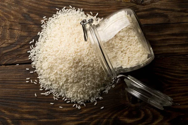 White uncooked, raw long grain rice in glass storage jar — Stock Photo, Image