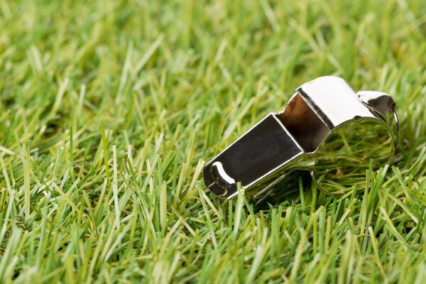 Soccer sports chrome whistle on grass background 