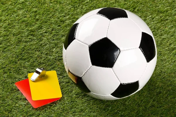 Футбольный мяч с желтыми и красными карточками и хромированным свистком — стоковое фото