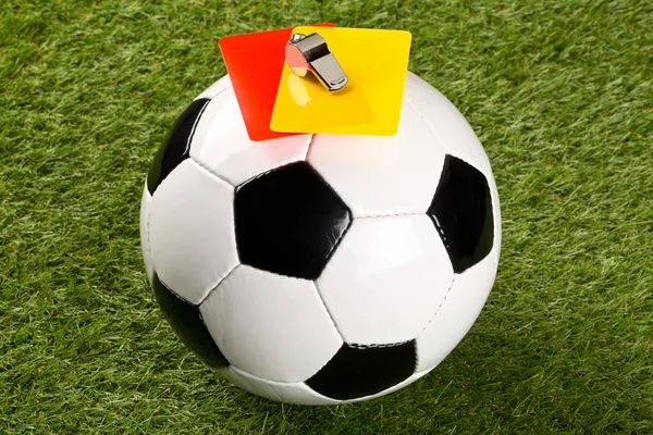 Футбольний м'яч з рефері жовті та червоні карти та хромований свисток на фоні трави — стокове фото