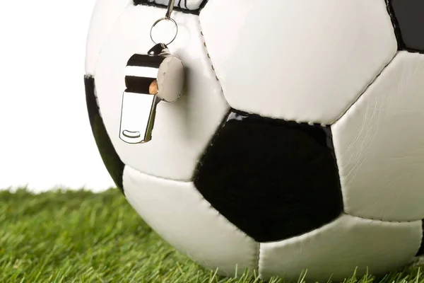 Pelota deportiva de fútbol blanco y negro con silbato de árbitro de cerca con enfoque selectivo en hierba verde — Foto de Stock