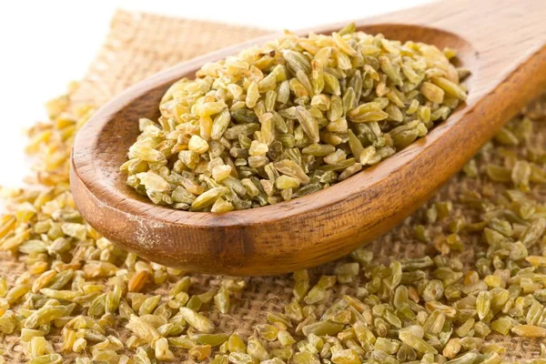 Heap of uncooked, raw freekeh or firik, roasted wheat grain — Stock Photo, Image