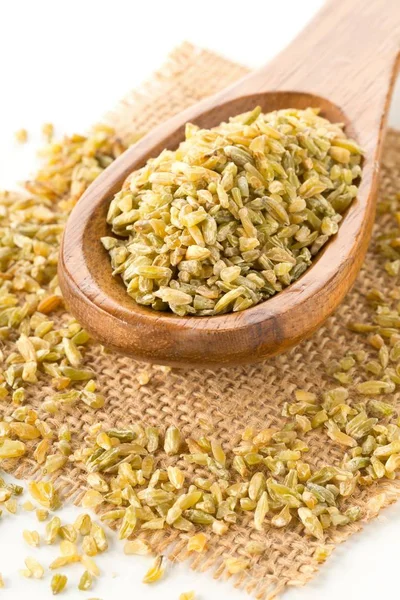 Heap of uncooked, raw freekeh or firik, roasted wheat grain, in wooden spoon on freekeh grain and burlap sack — 스톡 사진