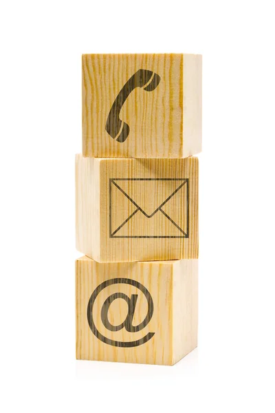 Contact us symbols with phone, e-mail and envelope icons on stacked brown wooden cubes on white