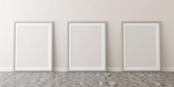 Leere Bilderrahmen lehnen an weiße Wand in hellem Raum mit braunem Holzboden mit Kopierraum — Stockfoto