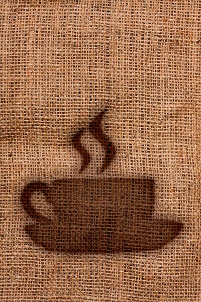 Coffee or espresso cup silhouette imprint with smoke on burlap jute sack — Stock Photo, Image