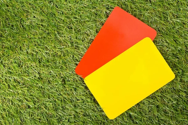 Árbitro deportivo de fútbol tarjetas amarillas y rojas en el fondo de hierba - pena, falta o concepto de deportes — Foto de Stock