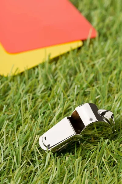 Soccer sports referee yellow and red cards with chrome whistle on grass background - penalty, foul or sports concept — Stock Photo, Image