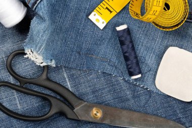 Yırtık mavi kot kumaş kumaş kumaş pantolon ve terzi aletleri - kot pantolon moda onarım veya onarım konsepti, yukarıdan düz bir görünüm yatıyordu