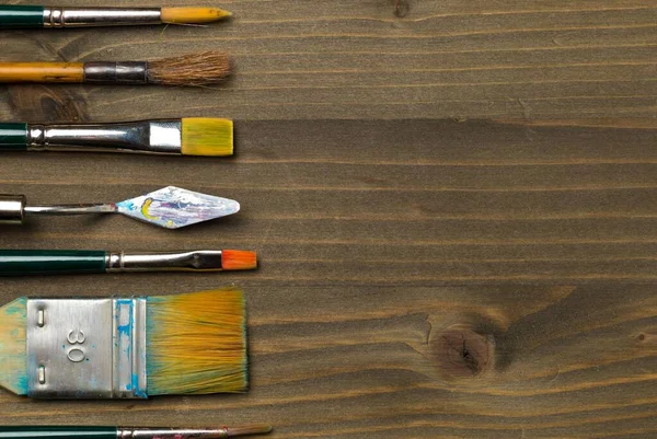 上からの平面図をコピースペースと茶色の木製の背景に絵筆で芸術用品を供給 — ストック写真