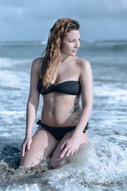 Deniz kıyısında poz yaz aylarında genç ve güzel bir kadın kum ile kaplı