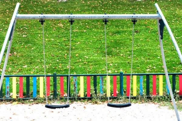 Swings hanging on chains in the playground — Zdjęcie stockowe