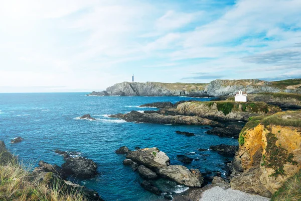 Kirche auf felsiger Klippe am Meer mit Leuchtturm im Hintergrund — Stockfoto