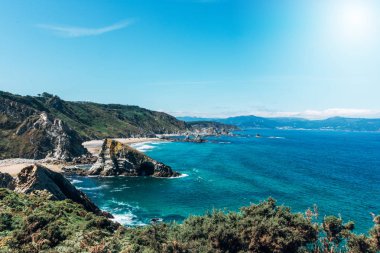 Okyanusun kıyısındaki kayalıkların altında beyaz kumsal