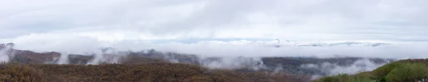 Gama de montanhas nevadas panorâmicas e cobertura de nuvens — Fotografia de Stock