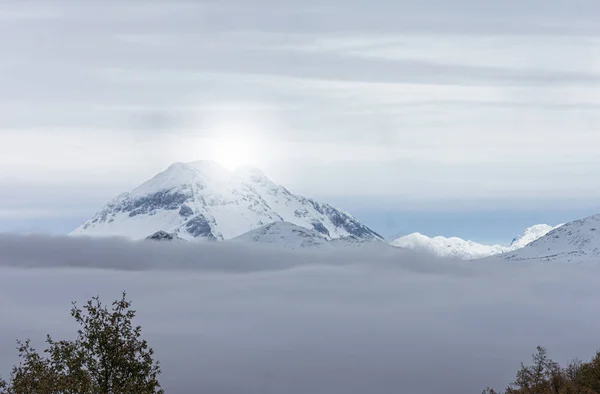 Λάμψη του ήλιου πάνω από την κορυφή του χιονισμένου βουνού — Φωτογραφία Αρχείου