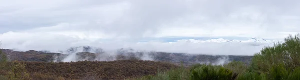 Gama de montanhas nevadas panorâmicas e cobertura de nuvens — Fotografia de Stock