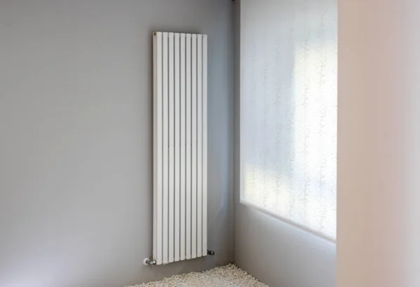 White radiator on gray wall with window 스톡 이미지