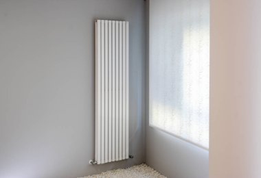 Pencereli gri duvarda beyaz radyatör
