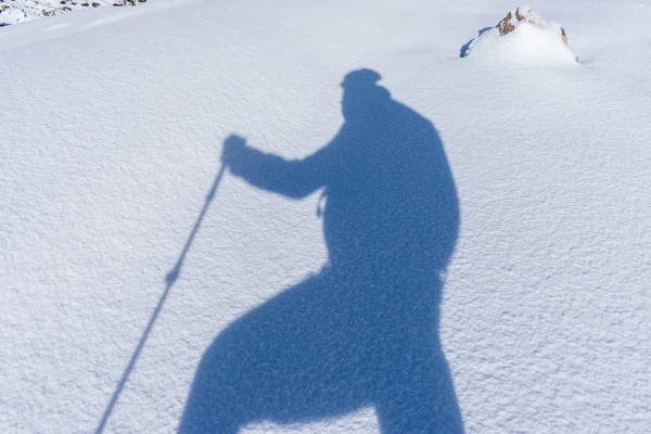 Shadow silhouette of a mountaineer on snow — Stock Photo, Image