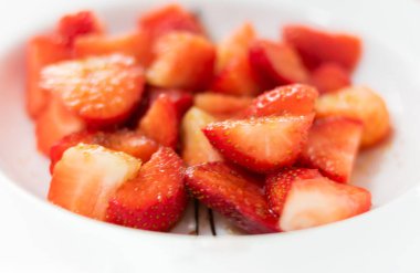 Kahverengi şekerli bir tabak çilek.