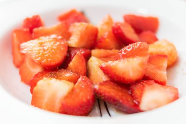 Kahverengi şekerli bir tabak çilek.