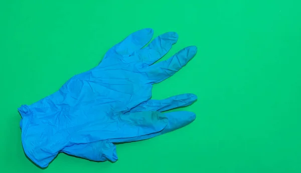 Stock image blue used hygienic gloves on green background