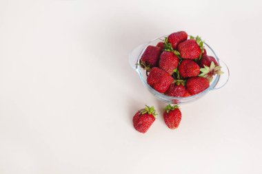 Juicy ripe strawberries in a bowl, isolated on a white background with space for text. Side view