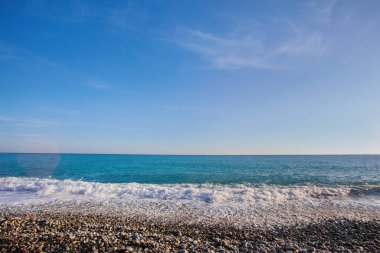 Fransa 'nın Nice kentindeki Promenade des Anglais' de deniz manzaralı çakıl taşı plajı