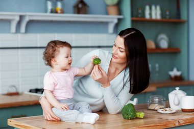 Annem bebek brokoli ve sebzeleri besler. Düzgün ve sağlıklı beslenme