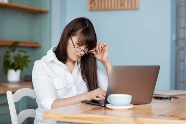 Menina Bonita Trabalhando Computador Cozinha Uma Menina Óculos Uma Camisa — Fotografia de Stock