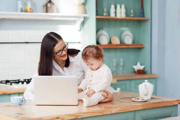 Jovem Mãe Trabalha Casa Com Laptop Com Bebê Nos Braços — Fotografia de Stock