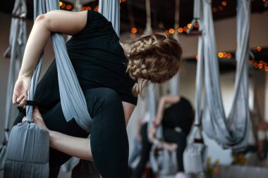 Spor salonunda hamakla yoga yapan bir kızın arka görüntüsü. Fitness Aero yogası