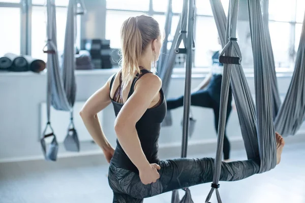 Atrakcyjna Młoda Kobieta Wykonuje Ćwiczenia Rozciągające Hamakami Aero Yoga Studio — Zdjęcie stockowe