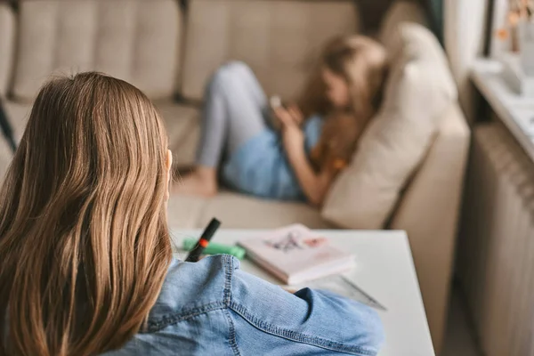 Una Adolescente Hace Tarea Mientras Hermana Juega Teléfono Comunicación Distancia — Foto de Stock