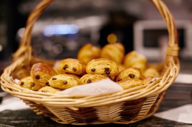 Taze pişmiş kruvasanlar ve masada duran hasır sepetin içinde çıtır çıtır ekmek. Kahvaltı için fırınlanmış mallar, Fransız Kahvaltısı