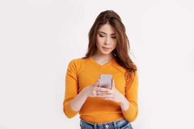 Genç ve güzel bir esmer, arkadaşlarıyla cep telefonu kullanarak iletişim kuruyor.