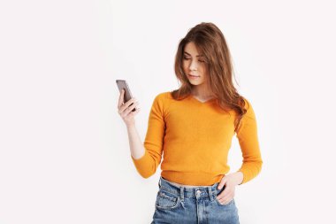 Çekici kız telefona bakar ve mesajlara cevap verir.