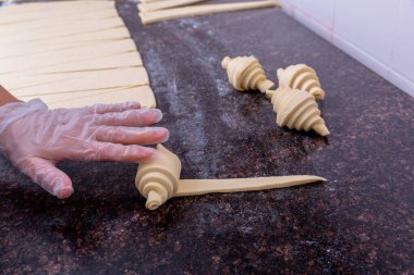 Mutfakta bir pasta şefi hamur işleri yapıyor. Şef hamuru kruvasana çeviriyor. Mutfakta master dersi var. Yemek pişirme süreci. Adım adım. Özel ders. Yakın plan.