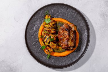 Hafif arka planda haşlanmış biftek, kızarmış patates ve kabak kreması. Avrupa mutfağı. Profesyonel bir şefin işi. Restoran menüsünden bir tabak. Üst görünüm.