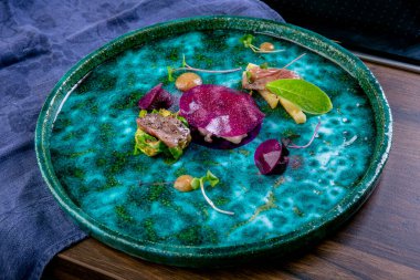 Somon balığı, sous vide teknolojisiyle kızartılmış patates ve tartar soslu kürelerle pişirilir. Restoran menüsünden bir tabak. Avrupa mutfağı. Yemek pişirme süreci. Yan görüş. Yakın plan..