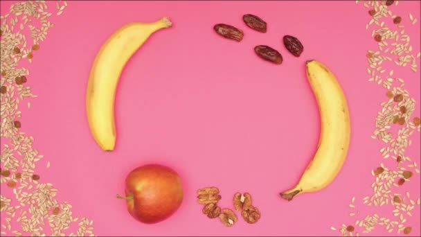Плоди, що обертаються, зупиняють рух на рожевому фоні — стокове відео