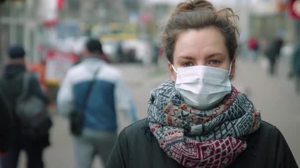 Mladá žena v davu nosí ochrannou masku — Stock video