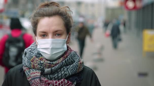 Mladá žena v davu nosí ochrannou masku — Stock video