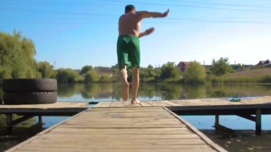 Adam koşuyor ve suya atlıyor, yaz aktivitesi, seyahat yaşam tarzı, yavaş çekim