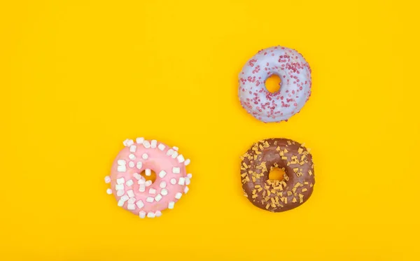 Zoete chocolade donuts op gele achtergrond. Dessert voedsel — Stockfoto